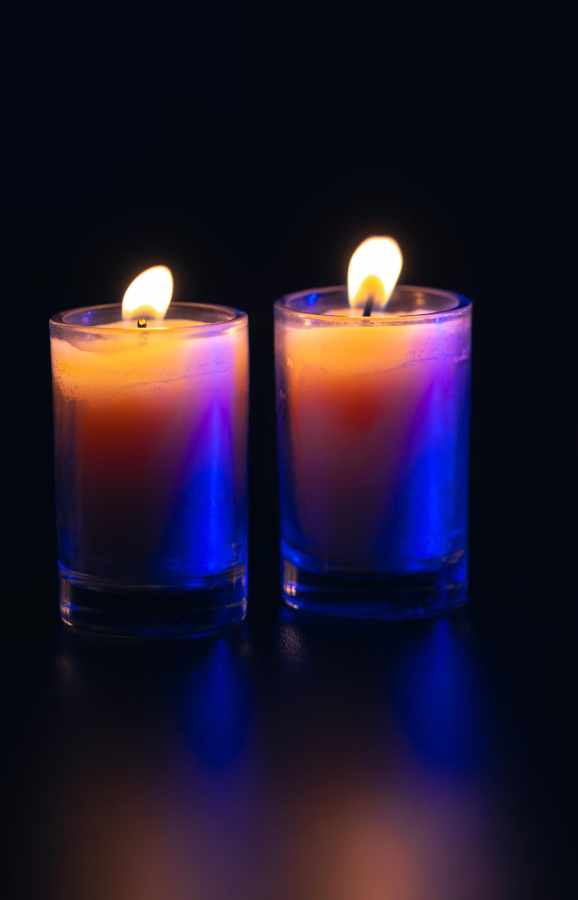 Burning candle on black background with backlight memorial day