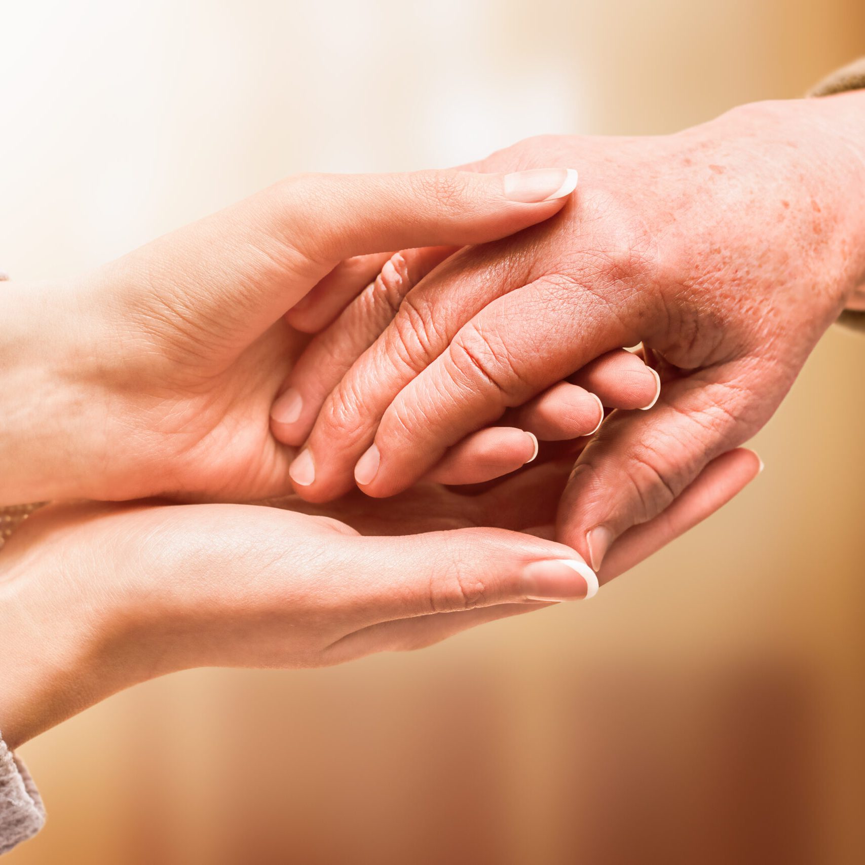 young hand holds hand of senior, care and help concept